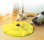 Two cats playing with a yellow cat toy on a wooden floor.